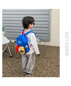 Detail of a kids color-block canvas backpack with yellow front pocket and blue straps