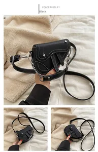 Détail du sac selle noir avec surpiqûres blanches et chaîne argentée pour filles