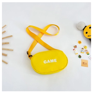Detail view of the durable yellow canvas kid's crossbody bag with bold white GAME letter print