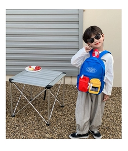 Detail of colorful children backpack with red mesh pocket and adjustable straps
