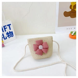 Détail d'un mini sac en paille pour filles avec une grande fleur en tissu violette
