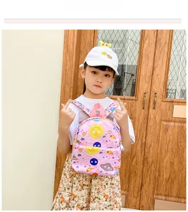 Pink toddler backpack featuring cartoon space and sun prints on a model for scale