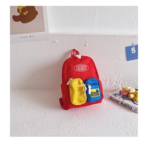 Detail of red canvas kids backpack featuring contrast color pockets and printed text