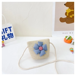 Détail du sac en paille pour enfants avec fleur bleue et bandoulière en corde