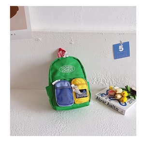 Detail of kids mini green backpack with contrasting blue mesh and yellow canvas pockets