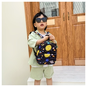 Detail of a lightweight black kids backpack featuring cartoon space and planet patterns