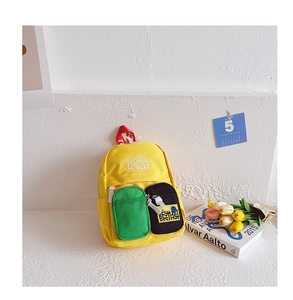 Detail of yellow canvas backpack with contrast pockets and embroidered lettering