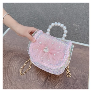 Detail of pink sequin girl's purse with mesh flower, pearl handle and crown accessory
