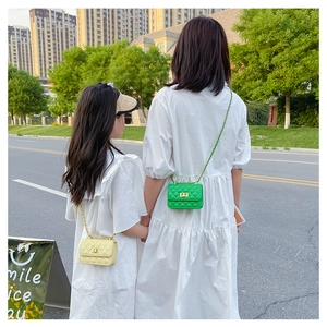 Détail des sacs à bandoulière matelassés vert et jaune pour un look assorti mère-fille