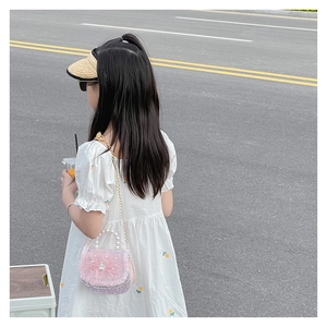 Detail of a pink woven princess bag with large floral accents and a pearl top handle