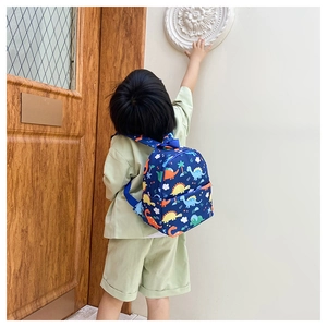 Detailed back view of a navy blue toddler backpack with colorful dinosaur print patterns
