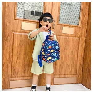 Detail of kids canvas backpack with colorful dinosaur print and adjustable blue straps
