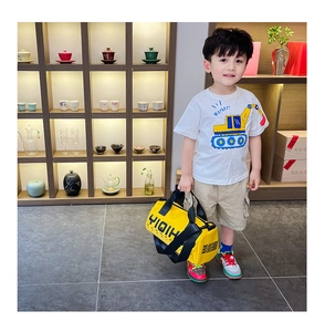 Gros plan d'un sac bandoulière jaune pour enfant et d'un t-shirt blanc à motif cartoon