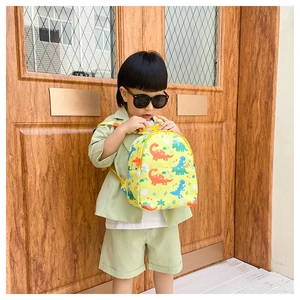 Toddler cartoon dinosaur backpack with yellow canvas fabric worn by a young boy