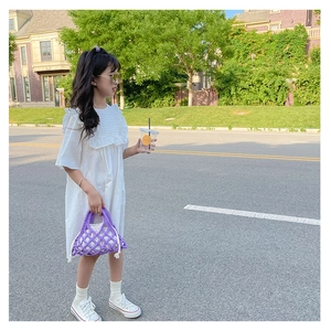 Close-up of a purple hand-knitted bucket bag with a white drawstring lining for kids