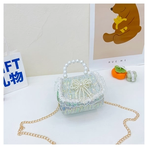 Détail du sac fille en tweed avec nœud en perles, dentelle et chaîne dorée