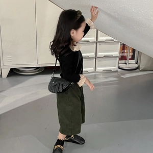 Tenue de mode pour fille avec haut à volants noir, pantalon large vert et sac de selle