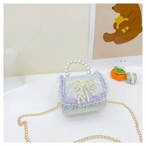 Détail du sac à main à paillettes bleu clair avec poignée en perles et nœud pour filles