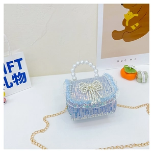 Détail du mini sac en tweed bleu à paillettes avec nœud et poignée en perles