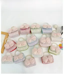 Detail of tweed children's handbags with pearl handles and oversized mesh bows in macro