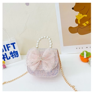 Detail of pink sequin kids handbag with mesh bow, crown ornament and pearl handle