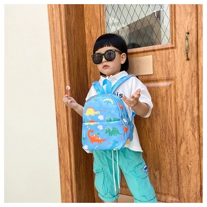 Close-up of bright blue kids backpack featuring colorful dinosaur prints and durable straps