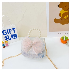 Macro detail of kids crossbody bag with blue sequins, pink tulle bow, and crown crystal