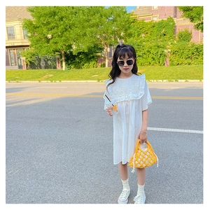 Outdoor street shot of a white cotton dress with fine ruffles and tiered frill details