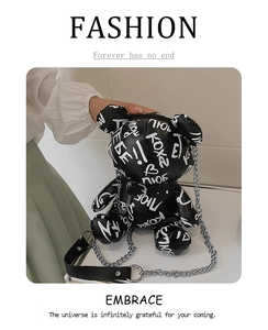 Detail of bear-shaped leather crossbody bag featuring white graffiti print and silver chain