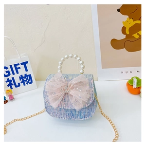 Detail of tweed girls handbag with sequin fabric, mesh bow and pearl handle