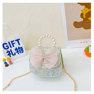 Detail of green tweed girl bag with pink bow, faux pearl handle and gold chain strap