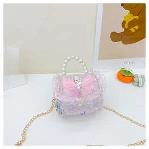 Détail du sac fille en tweed rose avec poignée en perles et emblème princesse