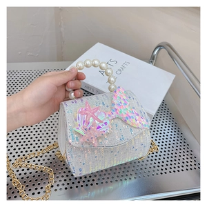 Detail of sequins mermaid shell bag with pearl handle and golden chain strap