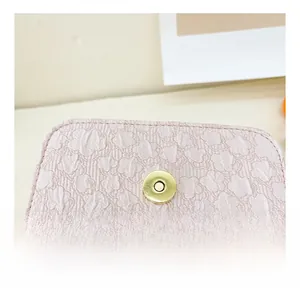 Detail of pink floral embossed leather bag featuring a premium gold magnetic clasp
