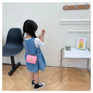 Fille portant un sac bandoulière matelassé rose avec fermoir doré et chaîne en métal