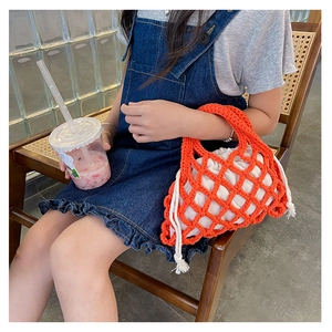 Kids orange crochet mesh bucket bag with white drawstring liner on a child model