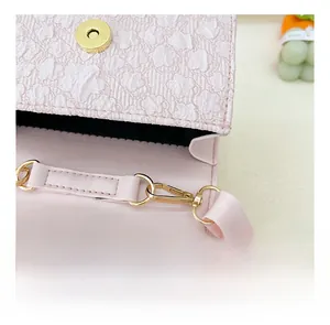 Close-up of pink bag with floral embossed texture and premium gold metal hardware detail