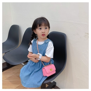 Détail du mini sac bandoulière matelassé rose avec chaîne dorée sur tenue en jean