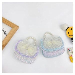 Detail of girls' sequin handbag with pearl handle and rhinestone crown bow decoration