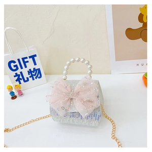 Close-up of glitter girls' bag with pink mesh bow, pearl handle, and golden chain