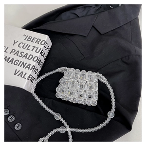 Gros plan d'un mini sac bandoulière fait main en perles transparentes sur un blazer