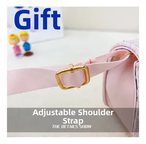 Detail of adjustable pink woven shoulder strap with gold metal buckle on girl's handbag