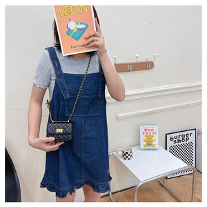 Mini sac à bandoulière matelassé noir avec robe en jean bleu dans un décor intérieur