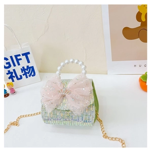 Detail of green tweed girls' handbag with pink sequin bow and pearl handle