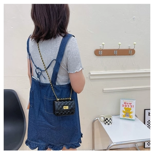 Vue détaillée d'un mini sac à chaîne matelassé noir porté par un mannequin dans un intérieur