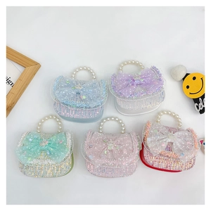 Flat lay of five glittery girl handbags with pearl handles and lace bow in various colors