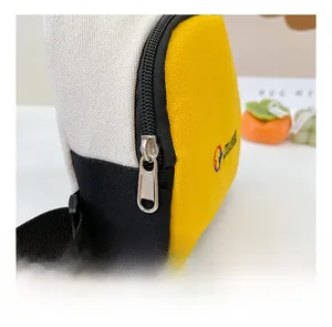 Détail de la vue latérale du sac bandoulière en toile tricolore avec fermeture éclair