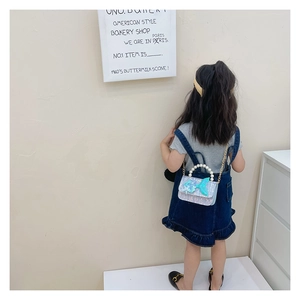 Girl wearing shiny mermaid tail bag with pearl handle and sequins from back view