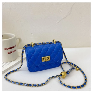 Vue détaillée du sac bandoulière matelassé bleu avec fermoir doré sur une table blanche
