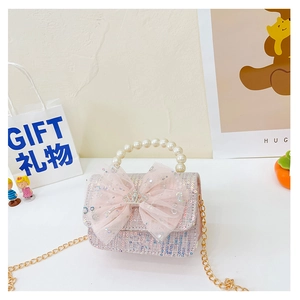Macro view of girls' tweed handbag featuring pearl handle and pink mesh bow with crown